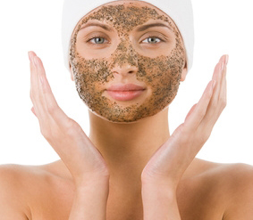 Beautiful woman with purifying facial mask keeping her palms by her face
